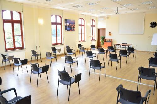 a room with chairs and tables on a wooden floor at WenderEDU Business Center in Wrocław