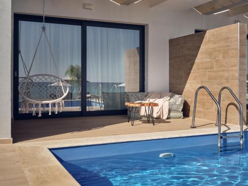 a house with a swimming pool and a patio at Cavo Orient Beach Hotel & Suites in Tragaki