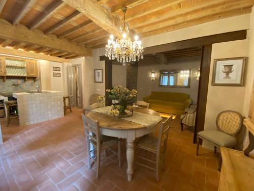 a dining room with a table and a chandelier at La Magione dei Todaro in Borgo a Buggiano