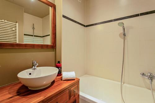 Un baño con lavabo blanco y ducha. en Villa Apollo, en Blankenberge