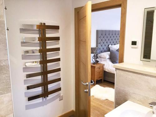 a bathroom with a towel rack next to a door at Woodland Lodge in Port na Long