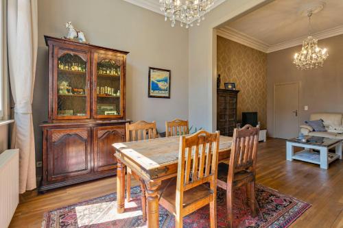 a dining room with a wooden table and chairs at Villa Apollo in Blankenberge