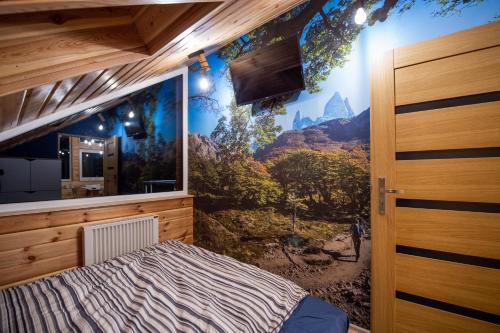 a bedroom with a mountain mural on the wall at Apartamenty Eksploris in Kudowa-Zdrój