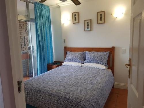 Schlafzimmer mit einem Bett mit blauer und weißer Bettwäsche in der Unterkunft Margate, Granada 104 in Margate