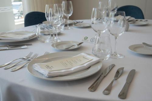 a white table with silverware and a white plate with a napkin at Luna Hotel de Tábua in Tábua