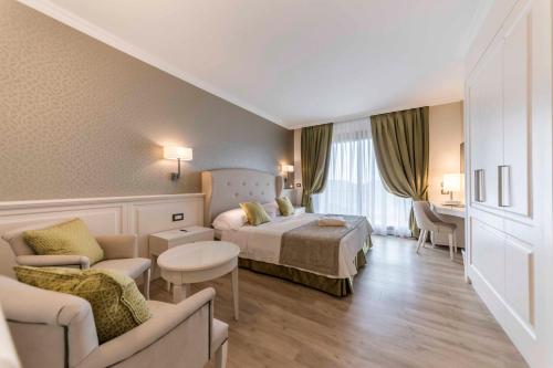 um quarto de hotel com uma cama e uma sala de estar em Madrigale Panoramic Lifestyle & Soulful Hotel em Costermano