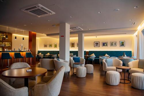 a restaurant with chairs and tables and a bar at Luna Hotel de Tábua in Tábua