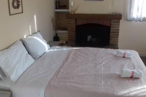 a large white bed with a fireplace in a room at Paris house 1 in Patra