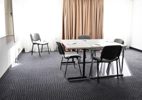 a conference room with a table and chairs and a window at Good Morning+ Hägersten in Stockholm