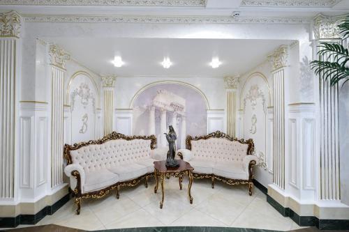 a room with two white couches and a statue at VICTOR Hotel Resort & SPA in Truskavets