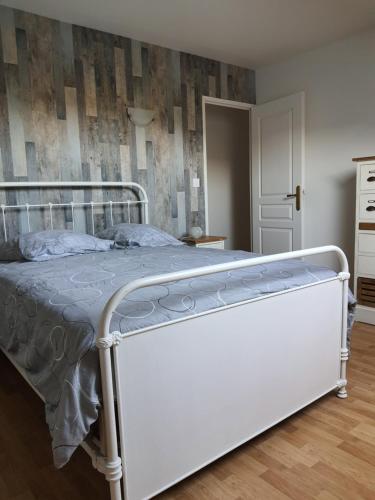 een wit bed in een slaapkamer met een muur bij Gite Ardennes in Deville