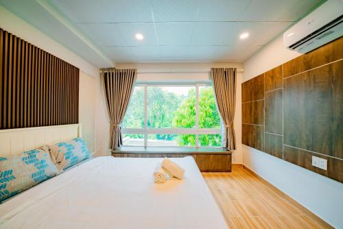 a bedroom with a large bed and a window at Kien Vang Bungalow in Phu Quoc