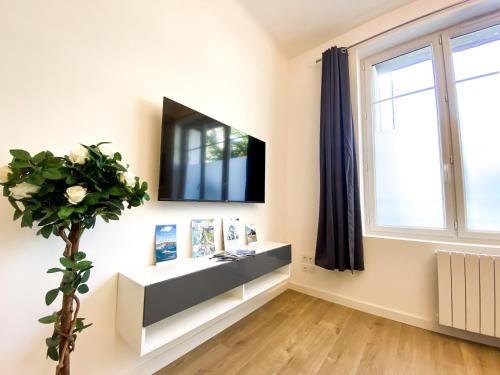 a living room with a tv and a window at APT bord de Mer, hypercentre Dinard, Parking prive in Dinard