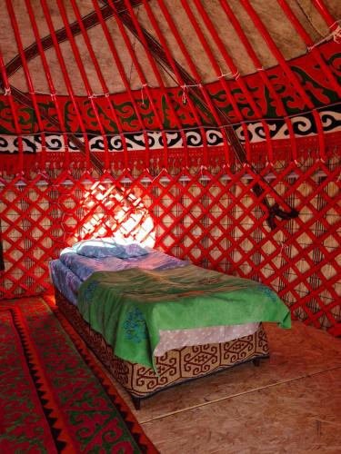 a room with a bed in a yurt at Feel Nomad Yurt Camp in Ak-Say