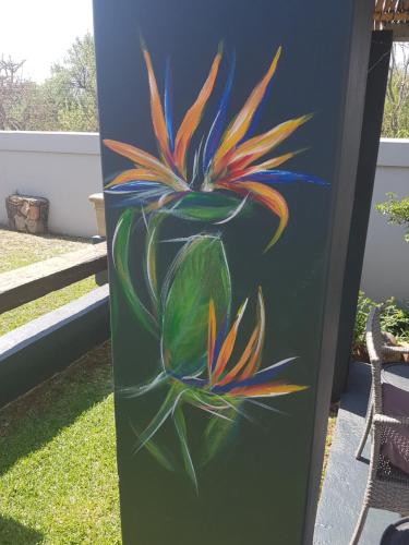 a painting of a flower on a pole at The Place Guesthouse Parys in Parys