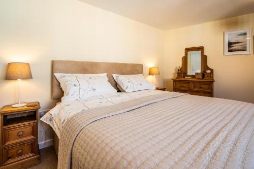 a bedroom with a large bed and a mirror at Buxton centre cosy cottage with free secure parking in Buxton