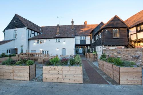 a group of buildings with wooden boxes with plants in them at The Ostrich Inn Colnbrook London Heathrow in Slough