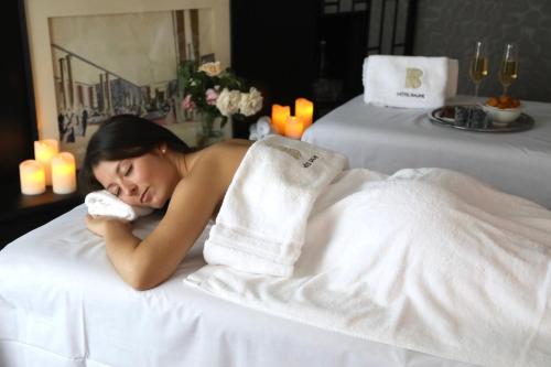 a woman laying in a towel in a massage room at H&ocirc;tel Baume in Paris