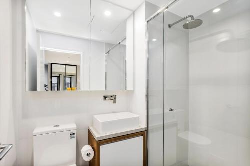 a white bathroom with a sink and a shower at KOZYGURU FORTITUDE VALLEY DESIGNER GRADE 2 BED APT FREE PARKING QFV179-1401 in Brisbane