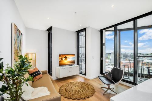 un soggiorno con pareti bianche e vetrate a tutta altezza di KOZYGURU FORTITUDE VALLEY DESIGNER GRADE 2 BED APT FREE PARKING QFV179-1401 a Brisbane