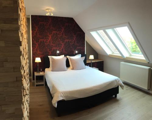 una camera da letto con un grande letto con una grande finestra di B&B Bella en Basiel a Bruges