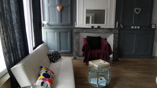 salon z kanapą i kominkiem w obiekcie Le Logis des Dames w mieście Sedan