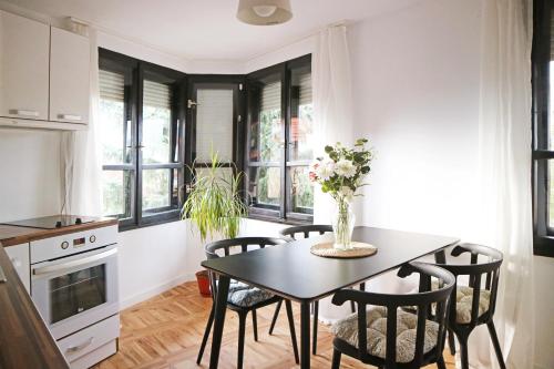 a kitchen with a table and chairs and windows at Modern Cozy Apartment - NEW in Kyustendil