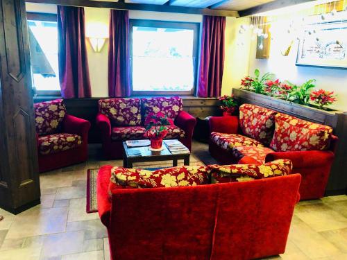 a living room with a couch and chairs and a table at Hotel Molino in Falcade