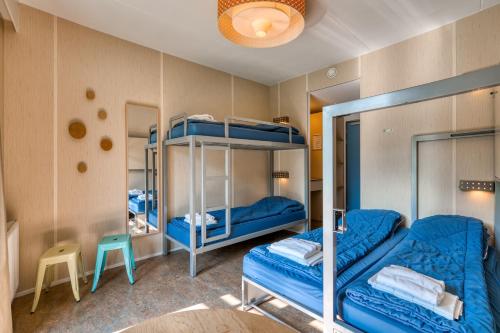 Cette chambre comprend 2 lits superposés et une chaise. dans l'établissement Stayokay Hostel Texel, à Den Burg