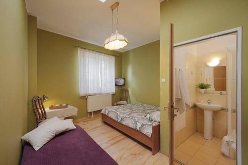 um quarto com uma cama e uma casa de banho com um lavatório em Villa Zosieńka em Gdansk