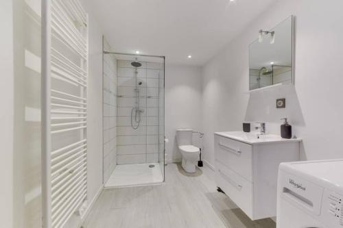 une salle de bain blanche avec douche et toilettes dans l'établissement Natural chic au coeur de Reims, à Reims