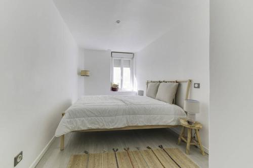 une chambre blanche avec un lit et une fenêtre dans l'établissement Natural chic au coeur de Reims, à Reims