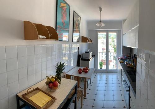 une cuisine avec une table avec un bol de fruits dessus dans l'établissement Appartement Front de Mer - Promenade des Anglais, à Nice