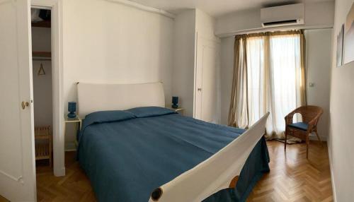 Appartement avec vue mer sur la Promenade des Anglais في نيس: غرفة نوم بسرير كبير مع بطانية زرقاء