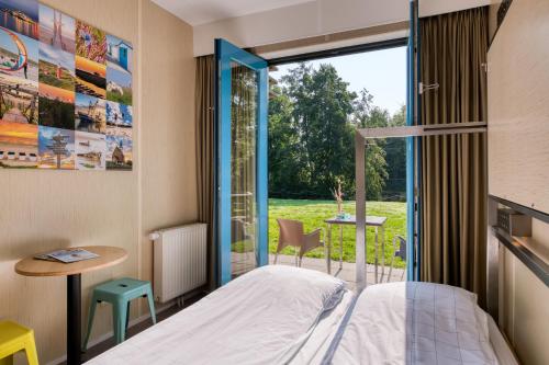 1 dormitorio con cama y ventana grande en Stayokay Hostel Texel, en Den Burg