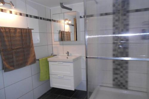 y baño blanco con lavabo y ducha. en Zimmer in direkter Nähe zu Basel, en Grenzach-Wyhlen