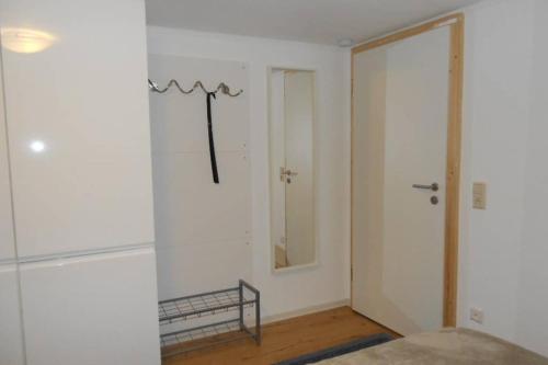 Habitación blanca con espejo y puerta en Zimmer in direkter Nähe zu Basel, en Grenzach-Wyhlen