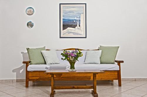 a couch with a vase of flowers on a table at Hotel Charissi in Mýkonos City
