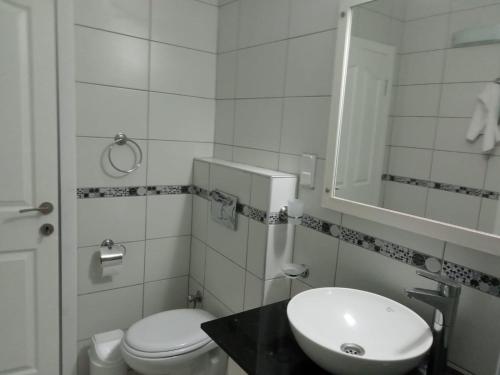 een witte badkamer met een toilet en een wastafel bij ORKA ROYAL HILLS E4 in Fethiye