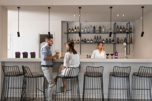 a man and a woman standing at a bar at Melina Oasis Boutique Hotel in Kassiopi