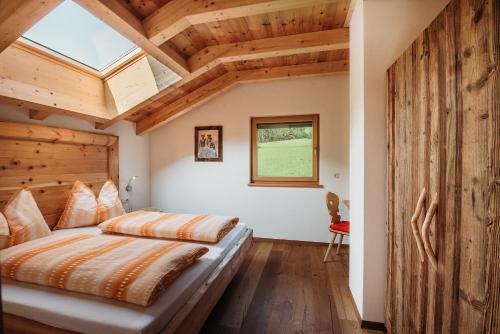 Schlafzimmer mit einem Bett mit Holzdecke in der Unterkunft Apartment Bawiglbach Grosskarneid in Lüsen