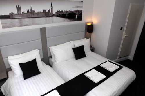two beds in a room with a picture on the wall at The Omega Hotel in London