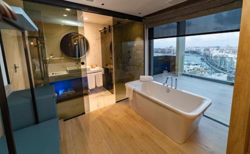 a bathroom with a bath tub and a shower at Mercure St. Julian's Malta in St Julian's