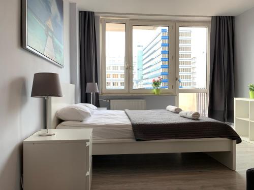 um quarto com uma cama e uma grande janela em Top Ten House Marszałkowska 8 em Varósvia