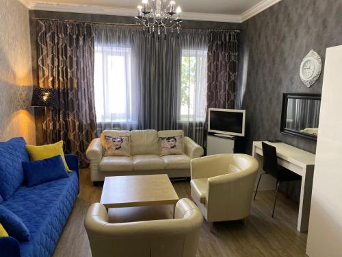 a living room with a blue couch and a table at Apartment na Kirova 37 in Pyatigorsk