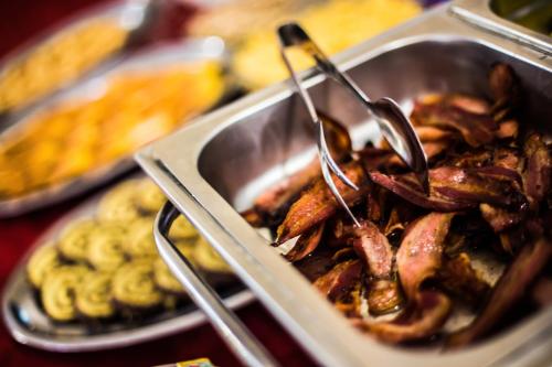 een schaal met eten met een tang op een dienblad bij Hotel Delle Nazioni in Cesenatico