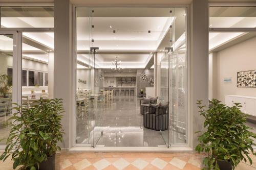 a lobby with glass walls and potted plants at Melina Oasis Boutique Hotel in Kassiopi