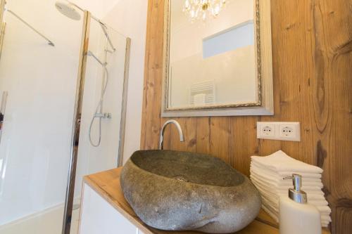 a bathroom with a large rock sink on a counter at Palais Gutenberg la Ville in Klagenfurt