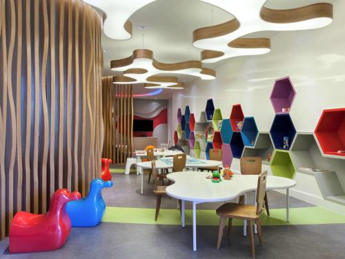 a restaurant with tables and chairs and colorful vases at Pullman Ciawi Vimala Hills Resort in Bogor