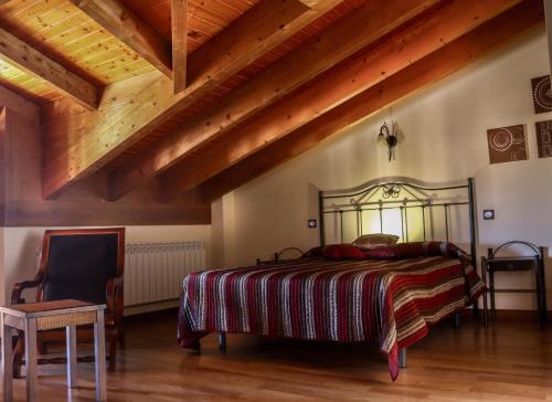 1 dormitorio con cama y techo de madera en Casa rural Ermita 1 y 2, en Burgos
